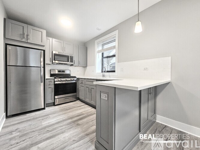 A modern kitchen with stainless steel appliances and a large island.