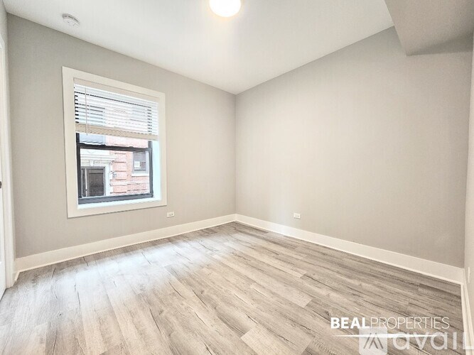 A room with a window and wooden flooring.