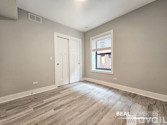 A room with a door and a window with a view of a building outside.