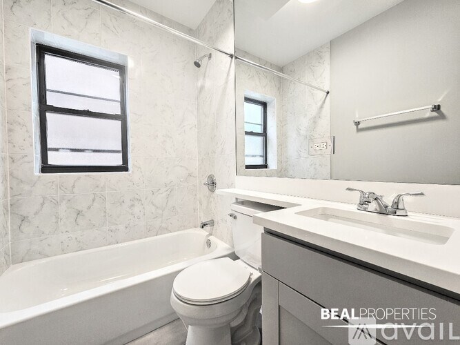A white bathroom with a toilet, sink, and bathtub.