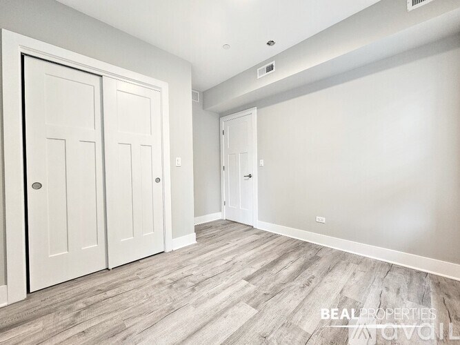 A room with two doors and a wall-mounted light fixture.