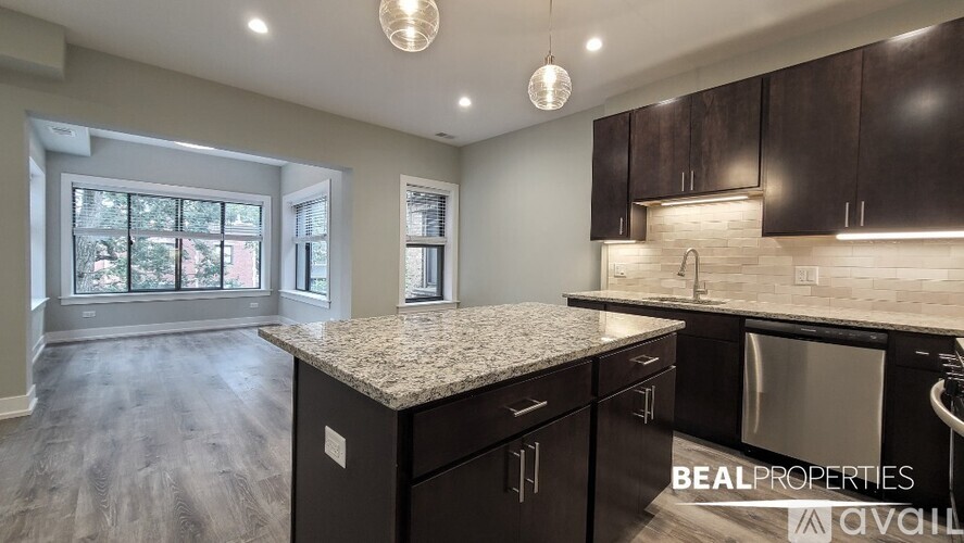 A kitchen with dark brown cabinets and a granite countertop.