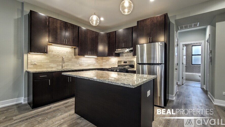 A modern kitchen with dark wood cabinets and a granite countertop.
