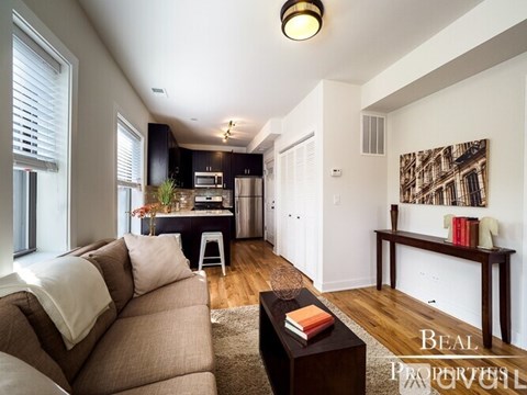 A living room with a brown couch and a coffee table.