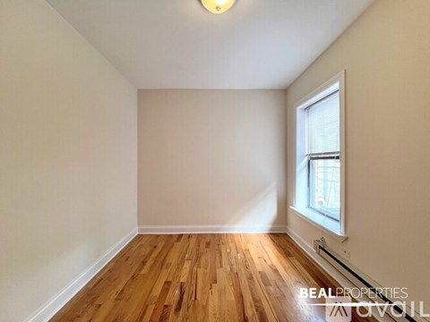 A room with wooden flooring and a window.