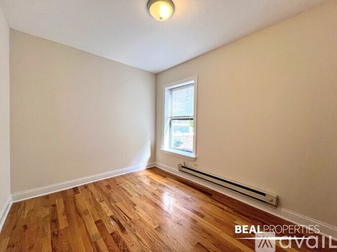 A room with wooden flooring and a window.