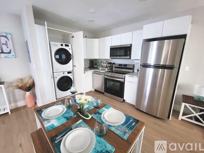 A modern kitchen with a dining table set for two.