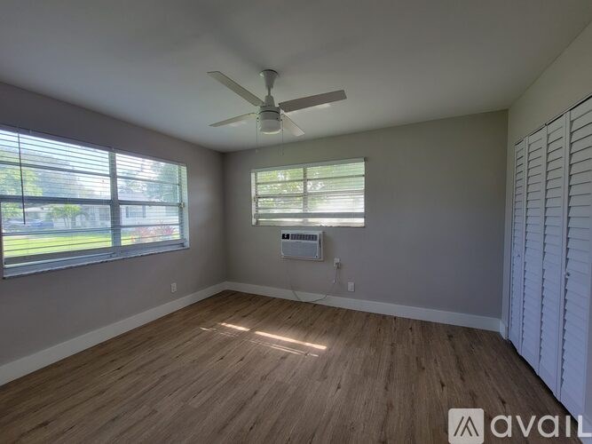 A room with a ceiling fan and a window with blinds.