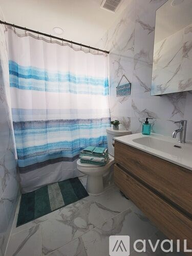 A bathroom with a white sink and a shower curtain with blue stripes.