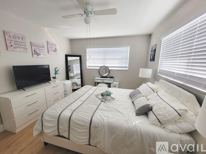 A bedroom with a bed, dresser, and television.