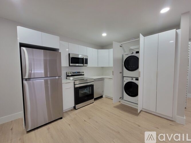 A kitchen with a refrigerator, oven, microwave, and dishwasher.
