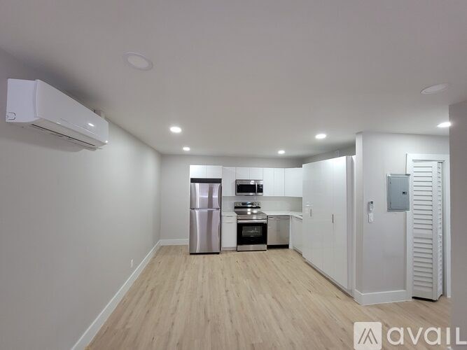A kitchen area with a stainless steel refrigerator, oven, and microwave.