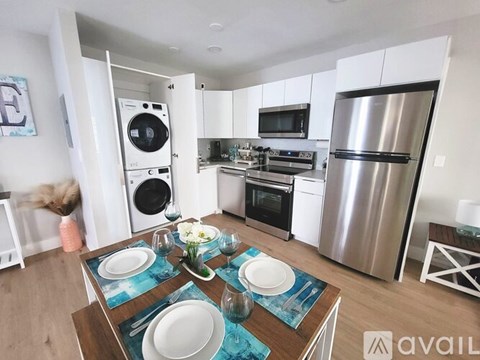 A modern kitchen with a dining table set for two.