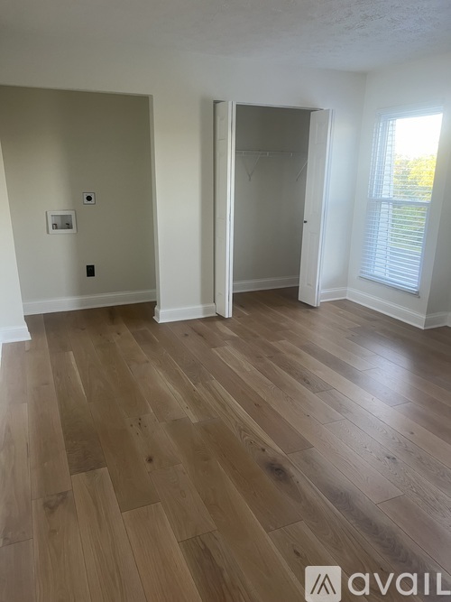 A room with wooden flooring and a white door.