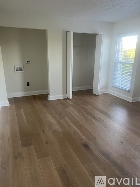 A room with wooden flooring and a white door.