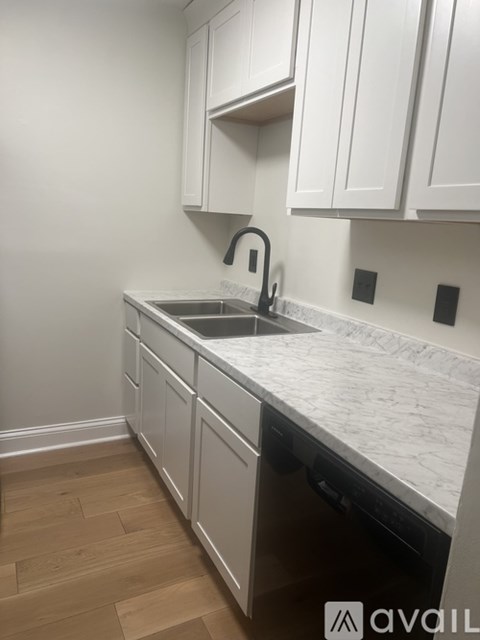 A kitchen with white cabinets and a marble countertop.