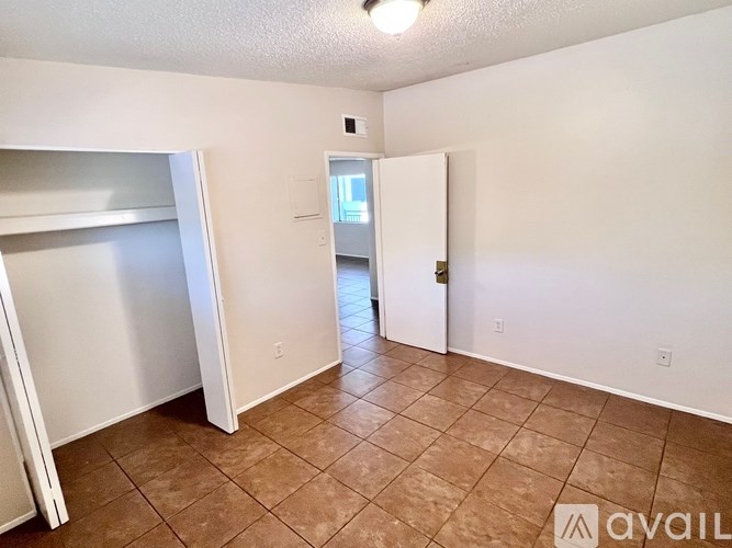 A room with a brown tile floor and white walls.