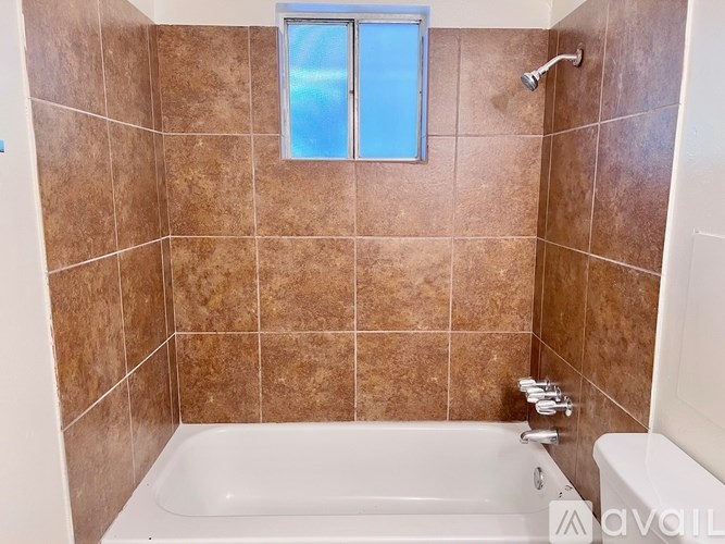 A bathroom with a tub and a window.