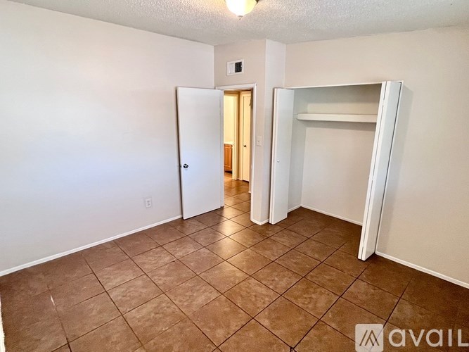 A room with a brown tile floor and white walls.