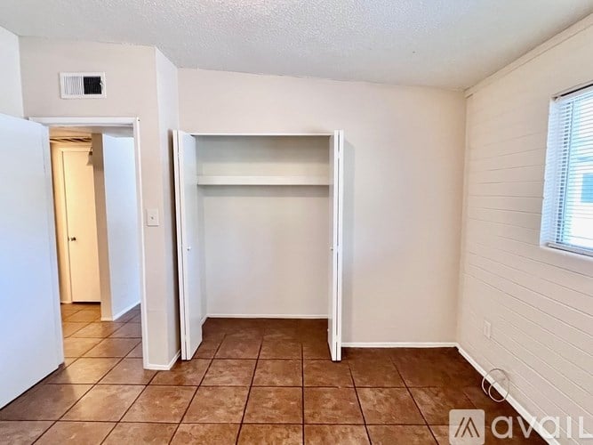 A room with a brown tile floor and white walls.