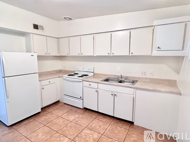 A kitchen with white appliances and cabinets.