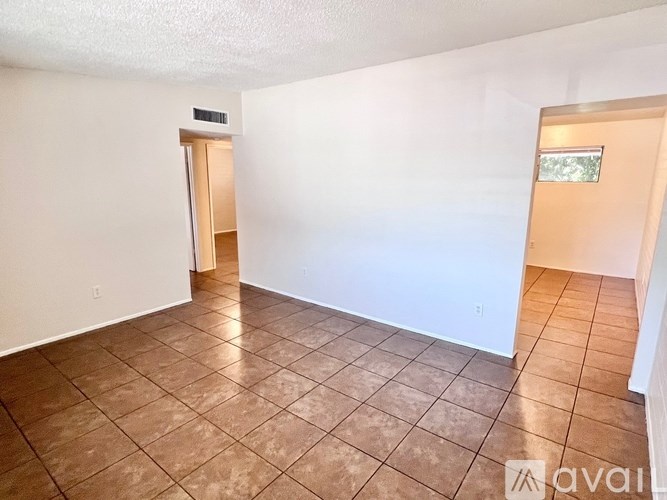 A room with tiled flooring and a door leading to another room.