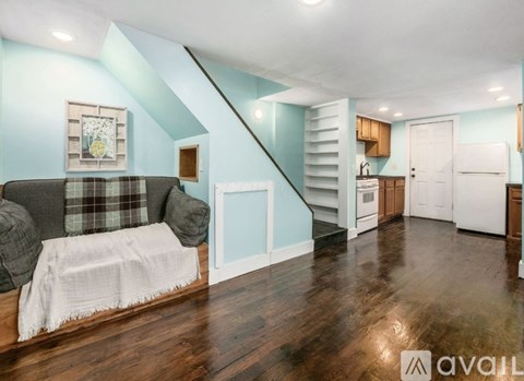 A living room with a couch and a staircase.