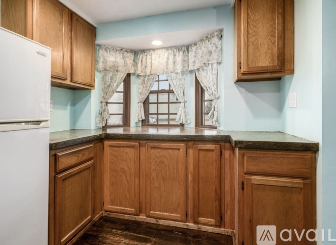 A kitchen with wooden cabinets and a white refrigerator.
