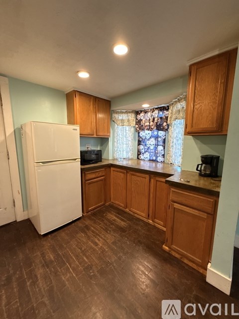 A kitchen with wooden cabinets and a white refrigerator.