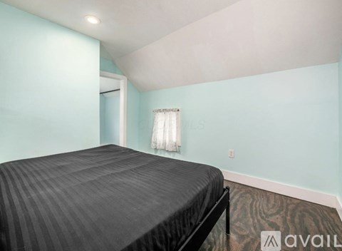 A bedroom with a bed and a window with curtains.