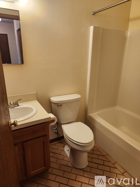 A kitchen with a tiled floor and wooden cabinets.