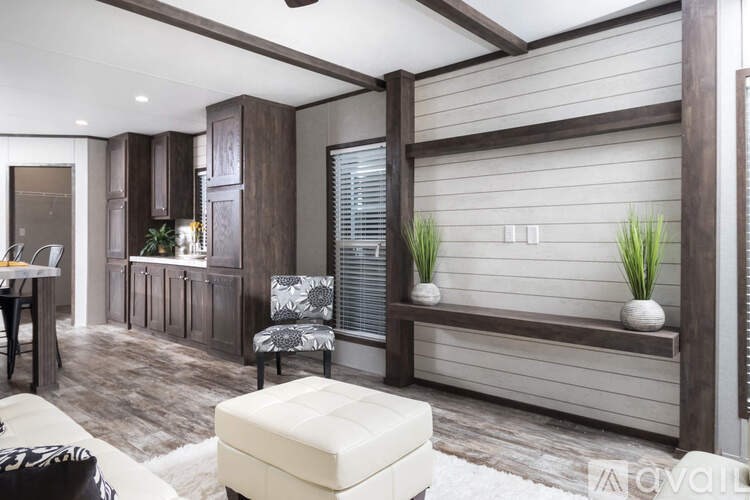 A modern living room with a white ottoman and a wooden bench.