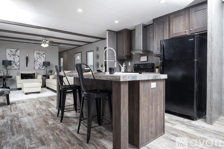 A modern kitchen with a black refrigerator and a bar area.
