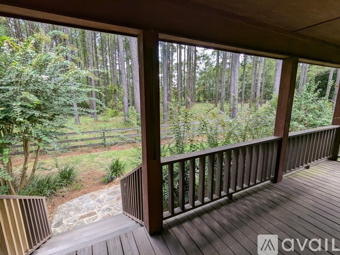 A wooden deck with a view of a forest.