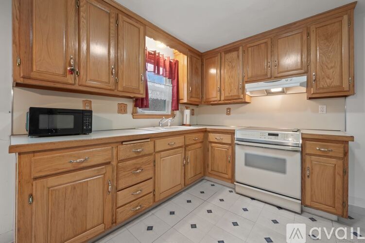 A kitchen with wooden cabinets and a marble countertop.