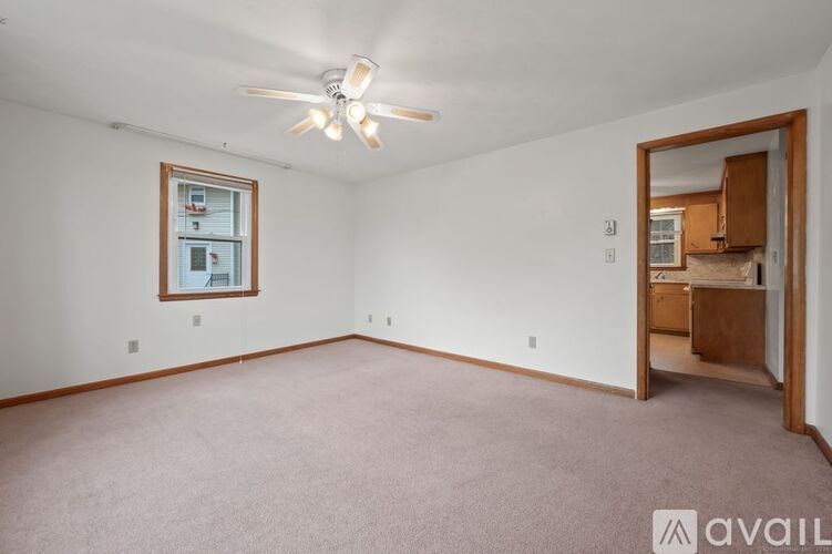 A room with a ceiling fan and a window.