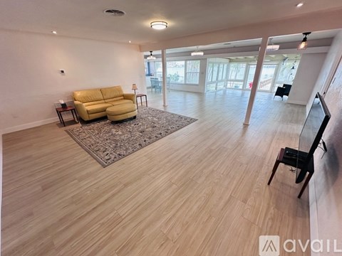 A living room with a yellow sofa and a rug.