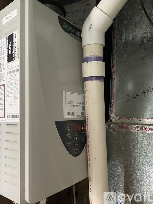 A white AO Smith furnace with a white pipe coming out of it.