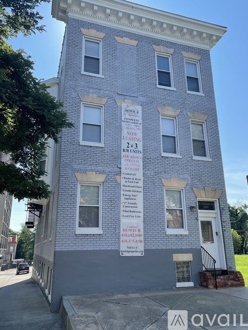 A building with a sign that says "AVAIL" on the bottom right.