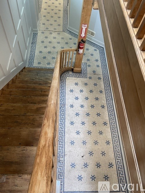 A wooden staircase with a tiled floor.