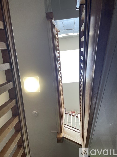 A stairwell with a light on and a sign that says exit.