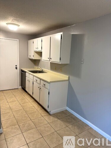 A kitchen with white cabinets and a beige countertop.