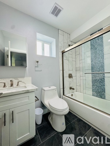 A white bathroom with a toilet, sink, and mirror.