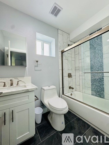 A white bathroom with a toilet, sink, and mirror.