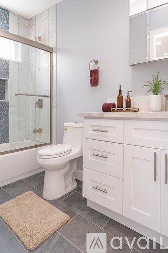 A white bathroom with a sink, mirror, and a door leading to a balcony.