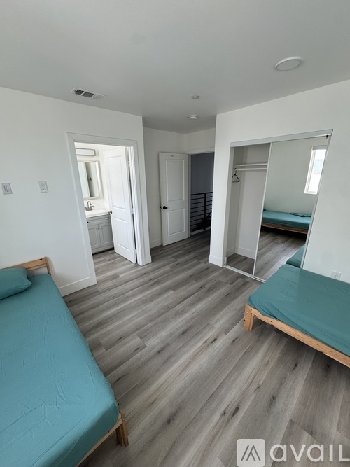 A bedroom with a bed, a wardrobe, and a mirror.