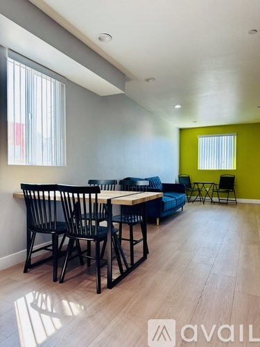 A room with a dining table and chairs and a sofa.
