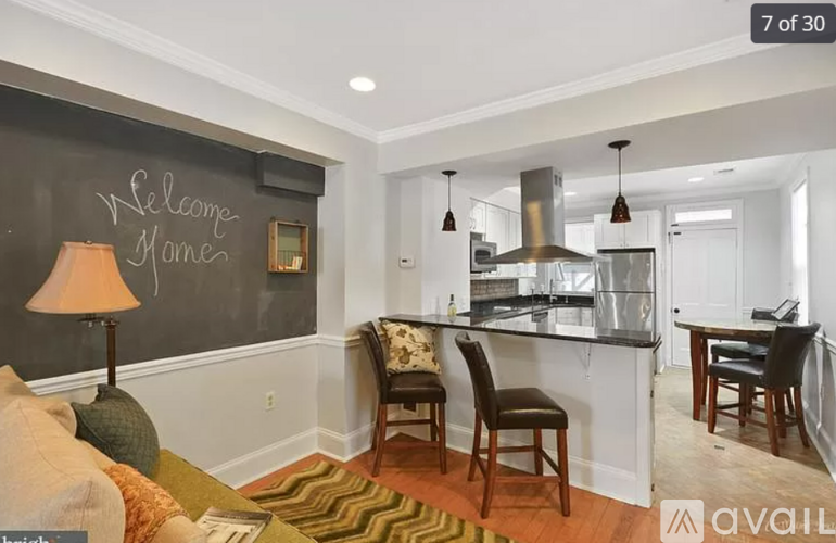 A kitchen area with a blackboard that says "Welcome Home" on the wall.