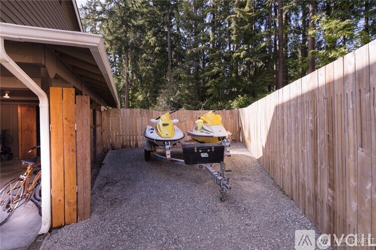 A yellow and black stroller is parked on a gravel driveway.