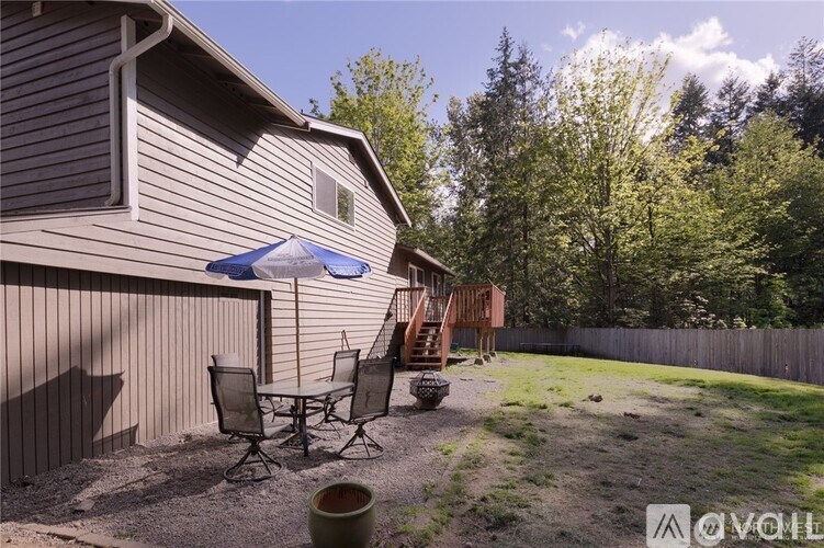 A patio with a table and chairs is set up outside a house.
